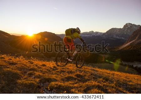 biker surfs the mountainside into the valley