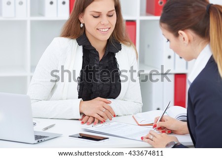 
Business, office, law and legal concept - picture of two woman signing contract paper.