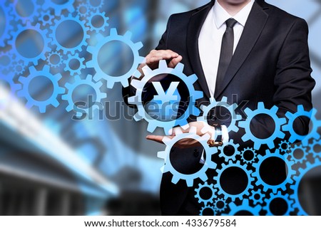 Glowing gear with icon "Yuan" in the hands of a businessman. Business concept. Internet concept.