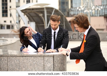 Business people sign a contract, street outdoors