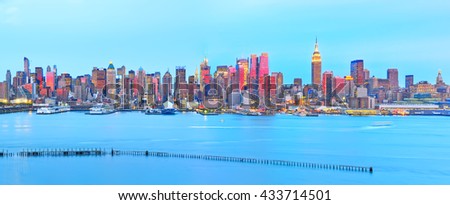 Manhattan skyline at dusk with red sunlight reflection.