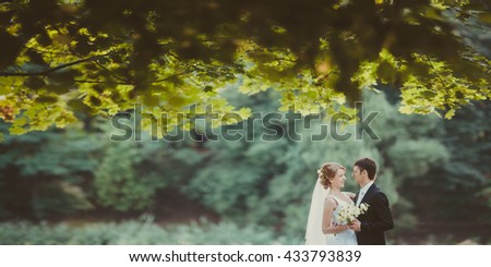 fragile bride and her husband walking in green park