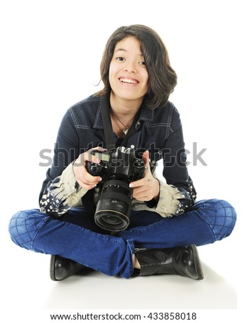 A pretty young teen looking up from her camera, delighted with the image she just saw.  Isolated on white.