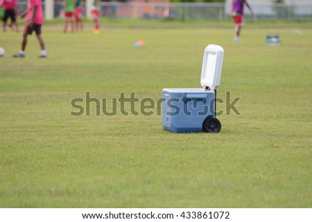 Cooler box on grass in soccer field.