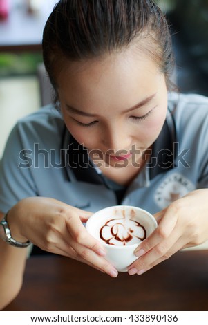 woman drinking coffee in the morning at restaurant (soft focus on the eyes)