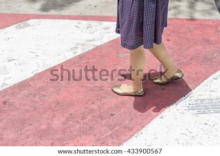 the woman working on no parking red cross zone.criss-cross red and white lines painted on the road
