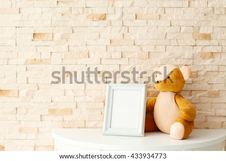 Baby toy and frame on brick wall background