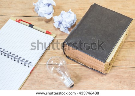 Note book and lamp on wooden background