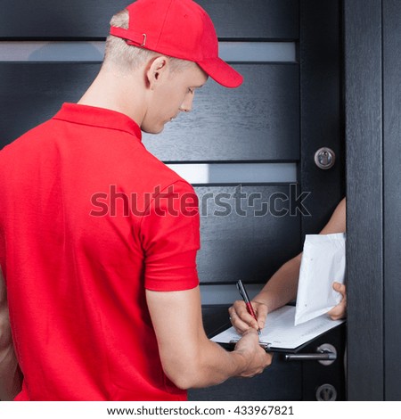 Courier in red uniform waiting for a signature