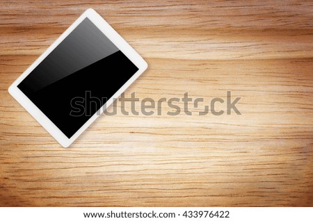 Digital tablet computer with isolated screen with clipping path on wooden background.