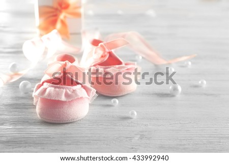 Baby booties on wooden table, closeup