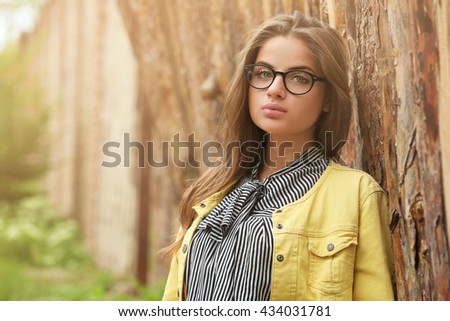 Long-haired young woman on fence background