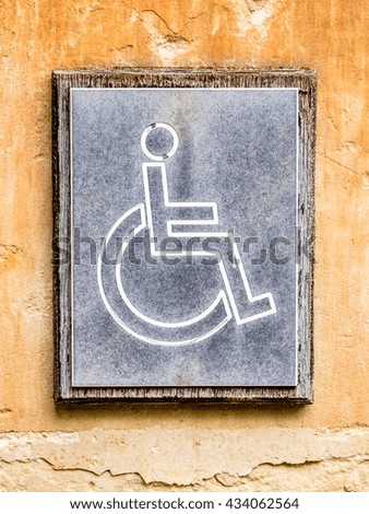 old disabled sign at a wall