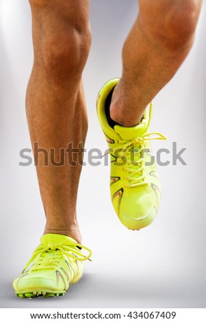 Close up of sportsman legs running on a white background against grey background