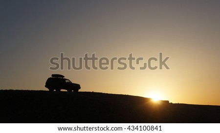 The car on sunset rides in mountains