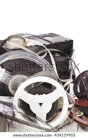 Vintage film camera rolls, old audio and video casettes with tape and foto strip on white background