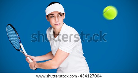 Female athlete playing tennis against royal blue