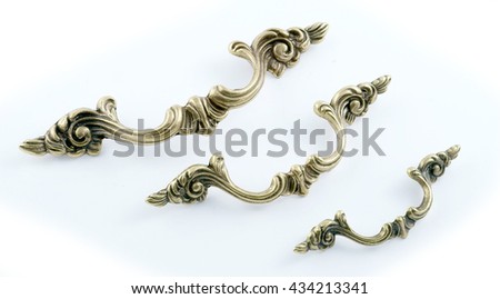 a set of handles for furniture in bronze on a white background