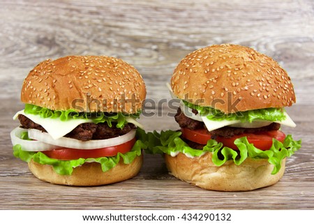 two beautiful juicy hamburger on a wooden table