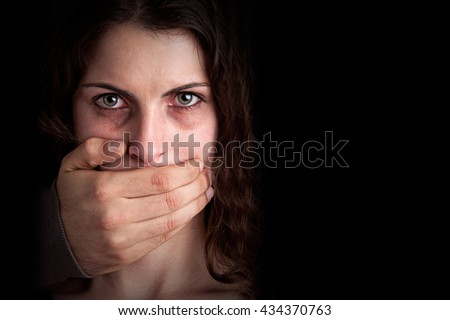 Closeup of a mans hand covering a womans mouth. Concept of domestic violence or kidnapping. Dark mood. Royalty-Free Stock Photo #434370763