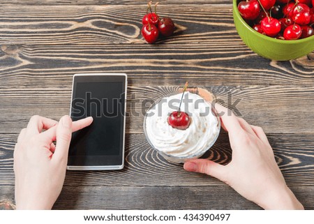 Woman Using Mobile Phone against Cherry. Technology Concept.