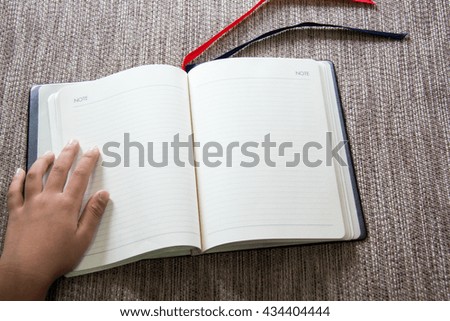 Note Book and Hand Asian Boy on Cloth Background .