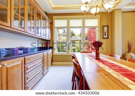 Nice red and brown dining room interior with wooden cabinets and blue granite counter top.