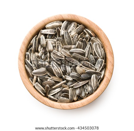 Unpeeled sunflower seeds in bowl isolated on white background. Top view.