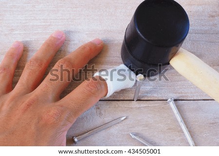 injured finger with medicine bandage on wooden background.