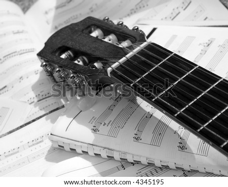 Acoustic guitar with sheet music in the background
