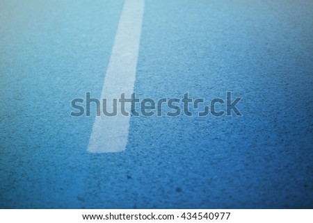 Turning road with marking lines and tire tracks. Close up photo with selective focus