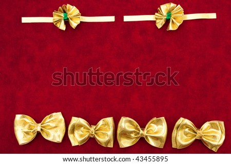 A gold ribbon bows sitting on a red background