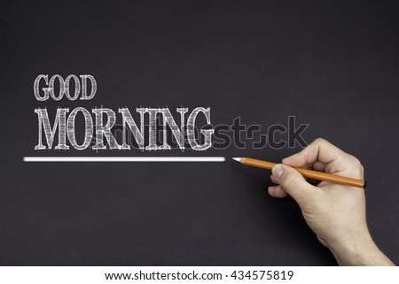 Hand with a white pencil writing: Good Morning