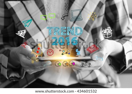 business holding a smart phone with TREND 2016 text on black and white background ,business analysis and strategy as concept