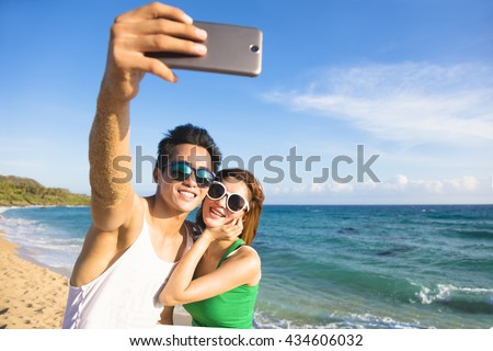 young couple  taking vacation selfie photograph at the beach

