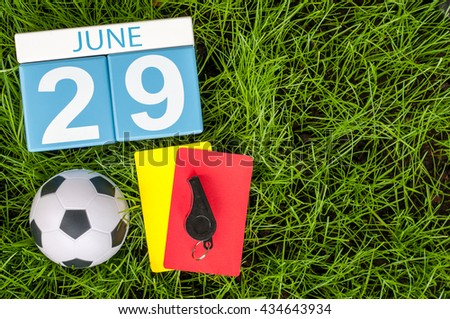 June 29th. Image of june 29 wooden color calendar on green grass background with football 