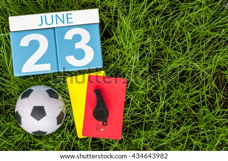 June 23rd. Image of june 23 wooden color calendar on green grass background with football 