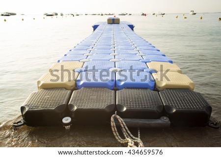 Plastic blue rotomolding jetty in the empty sea against blue sky.