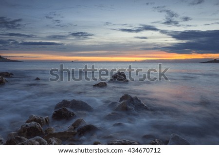 Sunset in Rogoznica Croatia Europe. Landscape and nature. Adriatic Sea at dusk. Calm summer evening with beautiful colors. Cloud, sky, rock, stone and reef.