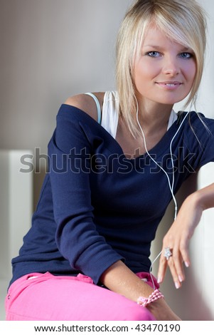 portrait of a pretty young blonde woman listening to music on her mp3 player