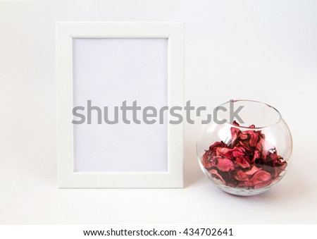 White picture frame with decorations. Mock up for your photo or text with bowl of flowers. Styled stock photography