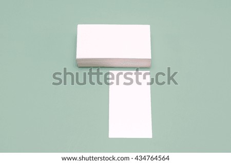 stack of business cards lay on a green background