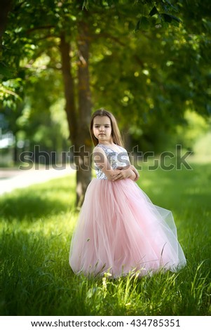 little girl in the lush dress in nature