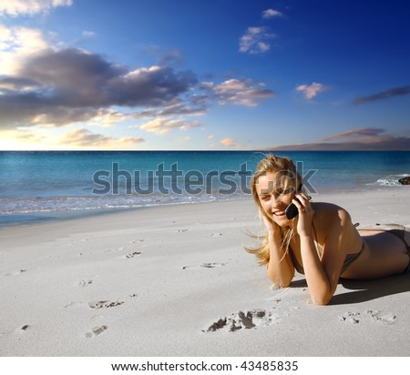 girl talking at mobile phone on the beach