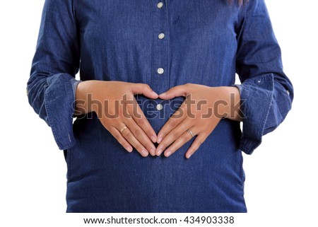 Close up portrait of pregnant belly of a woman in blue maternity dress, isolated on white background