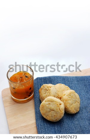 Home made scone with passion fruit jam close up on denim cloth and wooden plate. with copy space for clip art.