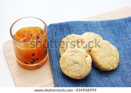 Home made scone with passion fruit jam close up on denim cloth and wooden plate. with copy space for clip art.