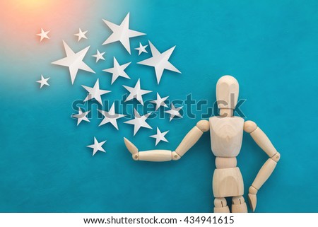 wood man figure presenting and showing star paper cut on color background