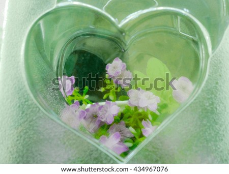 The shape of a heart made of clear glass and decorated with flowers.