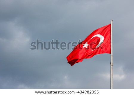 waving the Turkish flag on the background of clouds